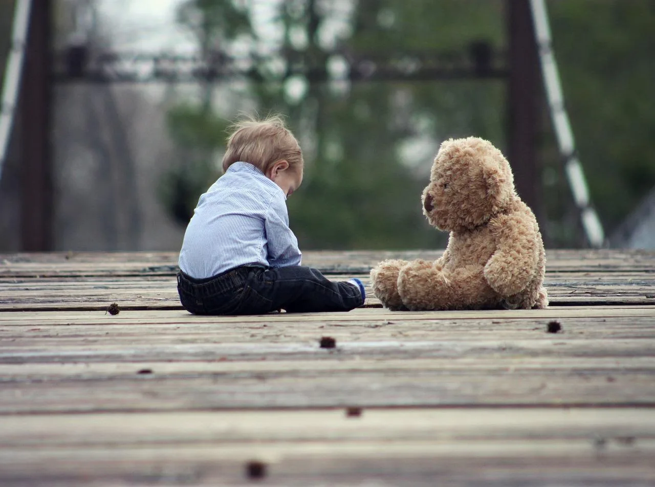 Kind mit Teddybär alleine